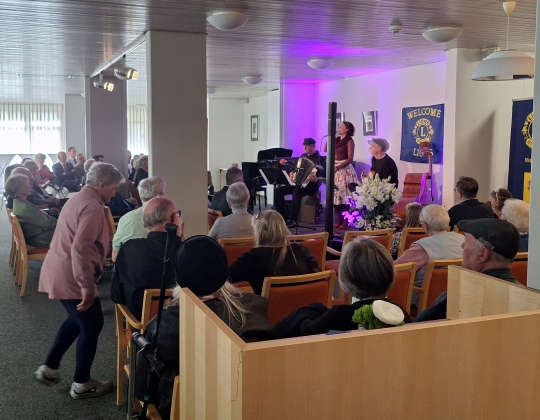 Das Foyer während des Konzerts anlässlich des 50-jährigen Jubiläums des Wohnstifts. Zu sehen sind gut gefüllte Sitzreihen welche vor den Musizierenden aufgestellt wurden.